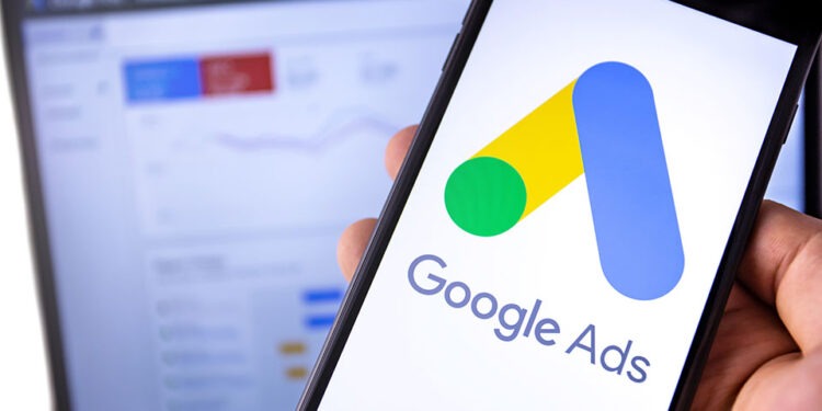 smartphone with Google Ads on the screen and display notebook background. Ads is a service of contextual, basically, search advertising from Google. Moscow, Russia - August 25, 2019